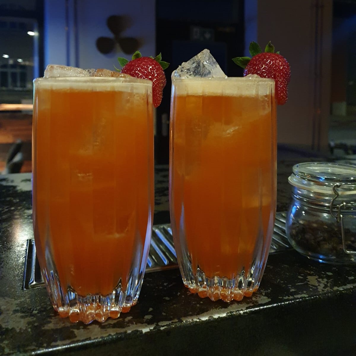 A bottle of Montelobos next to a red cocktail pictured from above